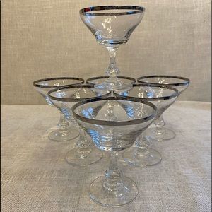 Six silver rimmed stem wine glasses.